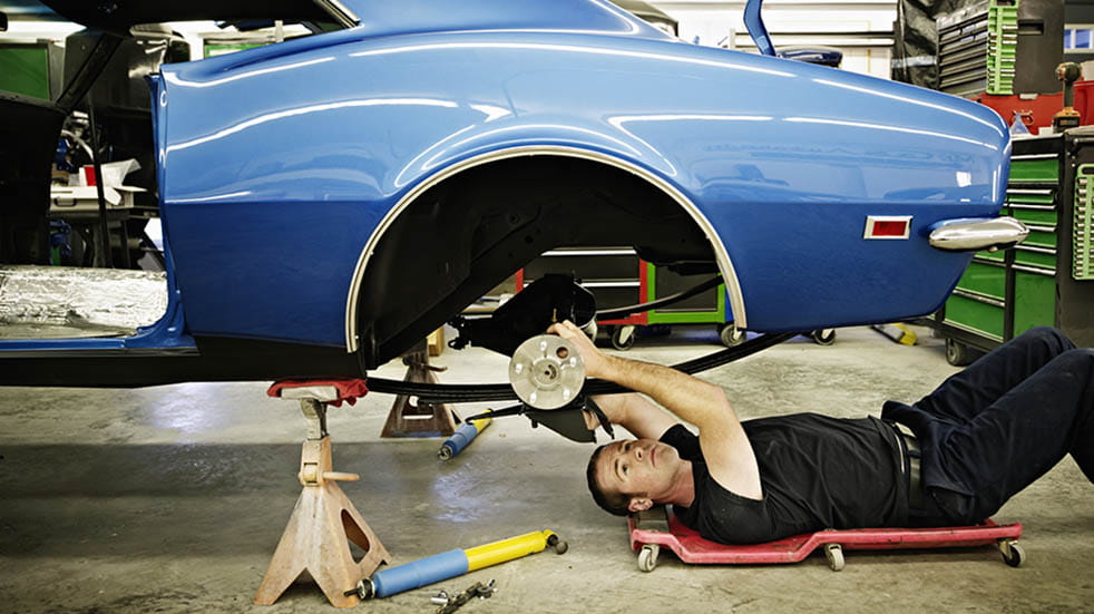 Restoring a classic car; man on floor